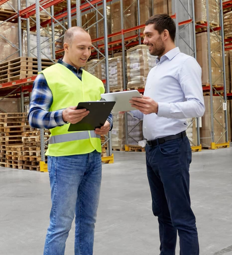 Warehouse worker and businessman with clipboard